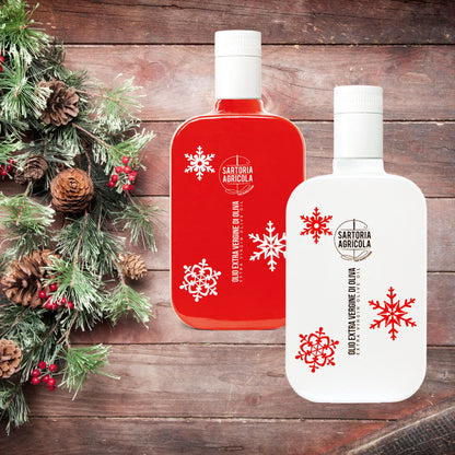 Red and white bottle of extra virgin olive oil, Christmas limited edition crafted in Puglia, with white snowflake design on rustic wood background.