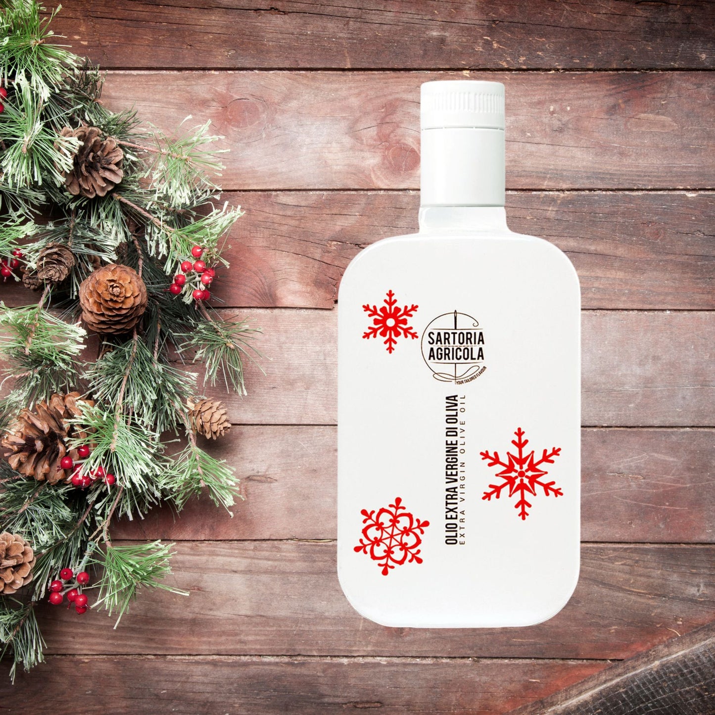 White bottle of extra virgin olive oil, Christmas limited edition crafted in Puglia, with white snowflake design on wood background.