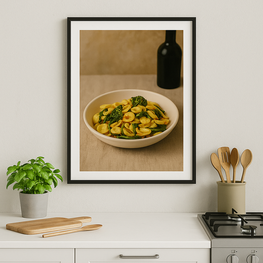 Mediterraanse poster met orecchiette en cime di rapa aan de muur boven een wit keukenblok – Puglia stijl, slow living sfeer.